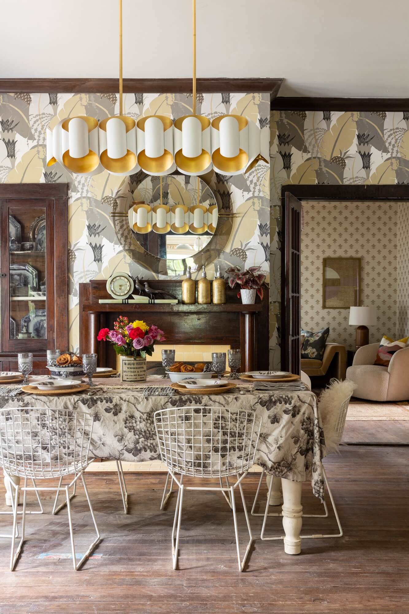 A dining room with mid century modern design, neutral wallpaper and eclectic interior design style.
