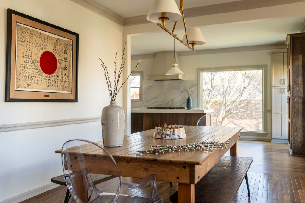 A custom dining room by Holly Thompson Design, with a rustic farmhouse dining table, custom Japanese art on the wall and high quality lighting.