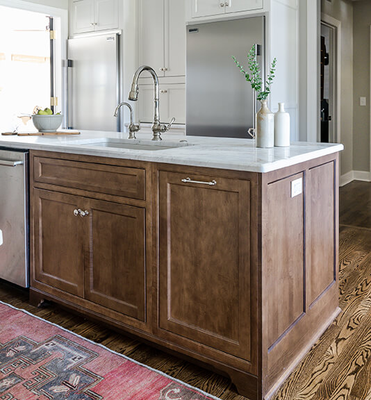 Luxury kitchen remodel with large island, marble countertop and natural wood cabinet fronts.