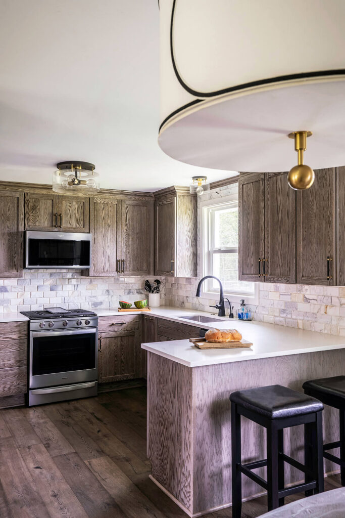 The lighting outside the kitchen with a white lamp shade, gold hardware and black details.